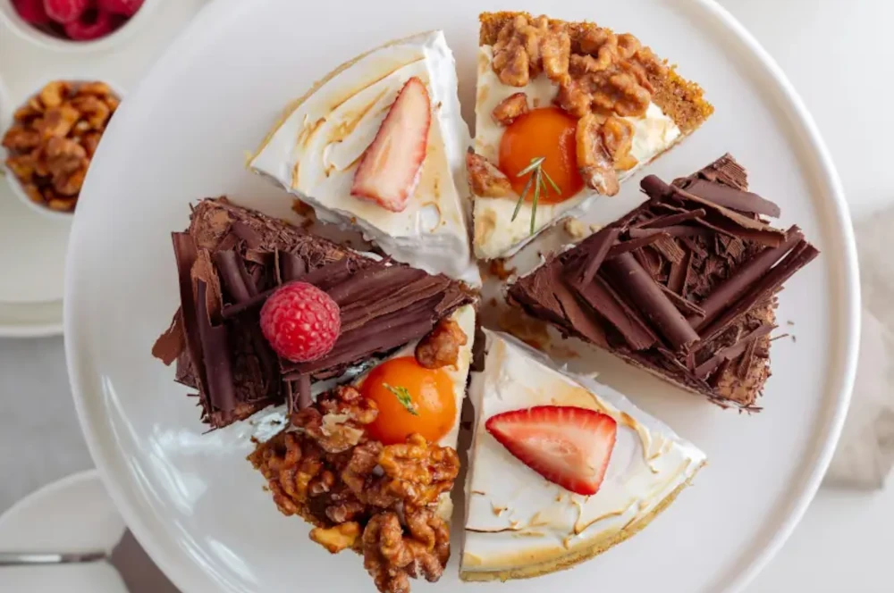a plate of different kinds of cake slices on a dining table